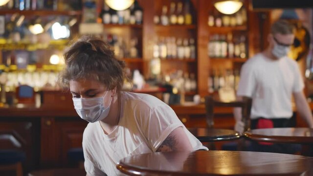Waiters wearing protective face mask cleaning restaurant before opening
