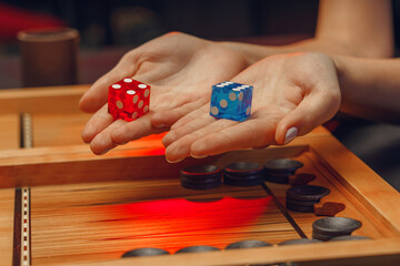 wooden backgammon and girl's hands with bones for the game
