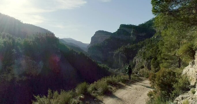 Mujer mirando por binoculares al borde de precipicio y dron se acerca