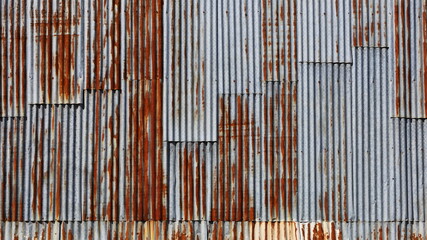 Rusty old galvanized wall. Metal background wavy red brown and silver grunge texture nasty. Full frame rate background for design. Selective focus
