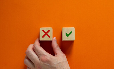 Yes or no choice symbol. Hand making a choice between two cubes with Yes and No icon on beautiful neutral orange background. Business and yes or no choice concept. Copy space.