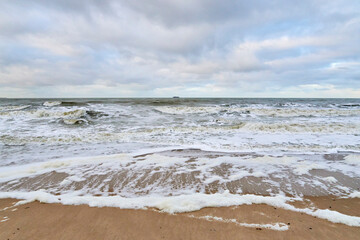 Fototapeta na wymiar paysage de la côte de la mer du Nord en Belgique avec des vagues au parc naturel du Zwin en hiver par temps nuageux