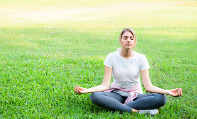 Woman sitting in lotus position closed eyes do meditation breathing technique outdoors, keep calm,...