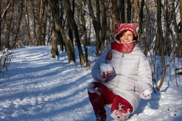 Girl with snowball sitting in the snow