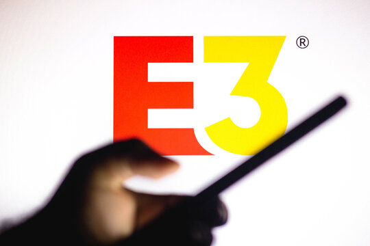 January 20, 2021, Brazil. In this photo illustration the Electronic Entertainment Expo (E3) logo seen in the background of a silhouette hand holding a mobile phone.