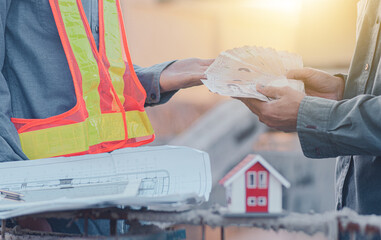 Businessman pay Salary for builder engineer in site construction