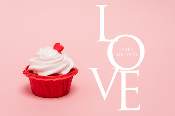 Valentines cupcake with red heart near love is all you need lettering on pink background