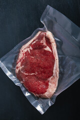 Aerial view of a vacuum packed ribeye for Sous Vide cooking at low temperature. Processed beef to...