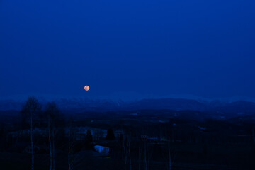 春の雪山から登る月