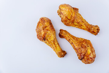 Roated chicken drumsticks marinated with buffalo sauce isolated on white background.