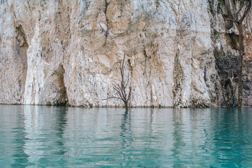 Beautiful minimalistic scene with dead tree and reflection in water and timber in turquoise water At Ratchaprapa dam, khao sok national park in surat thani southern of thailand.