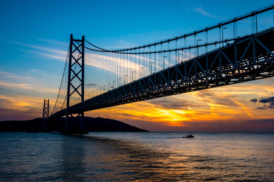 Akashi Kaikyo Ohashi Suspension Bridge in Kobe, Hogo Japan with golden sunset over the water