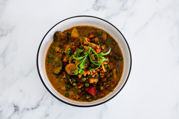 plant-based food, potatoes and garden vegetable roast with vegan broth and fresh tarragon
