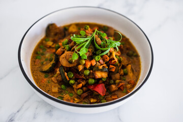 plant-based food, potatoes and garden vegetable roast with vegan broth and fresh tarragon