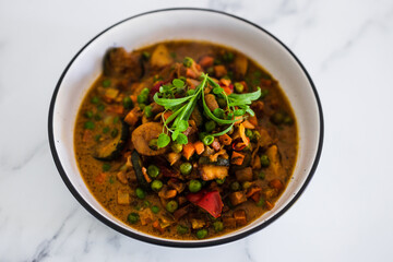 plant-based food, potatoes and garden vegetable roast with vegan broth and fresh tarragon