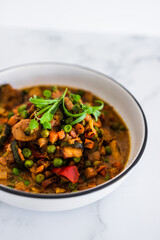 plant-based food, potatoes and garden vegetable roast with vegan broth and fresh tarragon