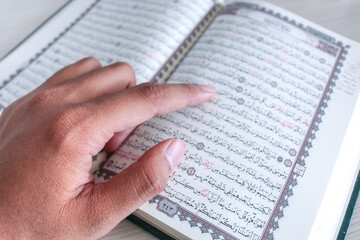 Obraz premium Close up of hand when reading the Holy Quran at the mosque. Selective focus