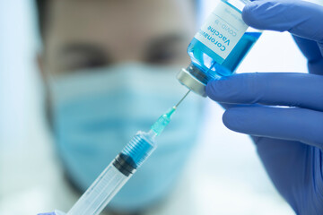 Doctor draws Coronavirus COVID-19 vaccine to syringe