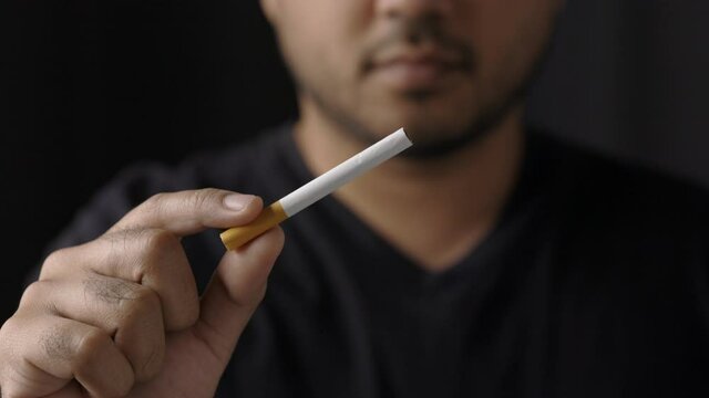 A young man with a cigarette He is going to smoke. Close up hand man showing a cigarette. World No Tobacco Day