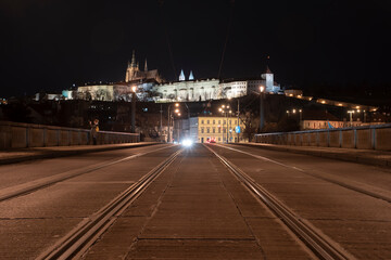 Fototapeta na wymiar .tracks for the tram on the road and in the background Prague Castle in the center of Prague and light from the street lights