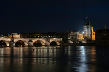 .panoramic view of Charles Bridge and illuminated street lights and the surrounding old architecture in the center of Prague in the Czech Republic at night