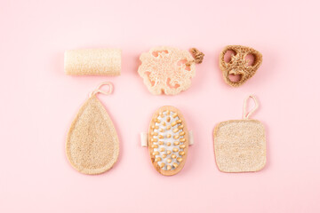 Fototapeta na wymiar Bathroom accessories, natural loofah sponge, wooden brush on pink background. Zero waste and plastic free concept, sustainable bathroom and lifestyle. Flat lay hygiene products.
