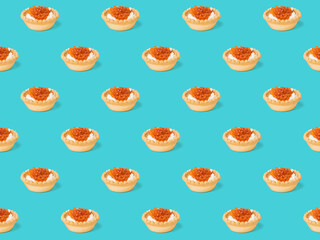 Seamless pattern of tartlets with cream cheese and caviar on a blue background.