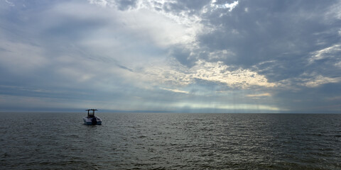 Boat anchored off Midle Cape Sable beach in Everglades National Park at sunset under dramatic winter cloudscape..