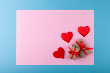 Red hearts, gift box with ribbon on colored background, pink in blue frame, valentine's day greeting card concept