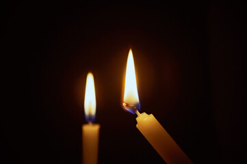Candle lit in the dark. Candle flame at night. Lighting design for background. lighting candles, Burning candle on black background. Candle in the dark.