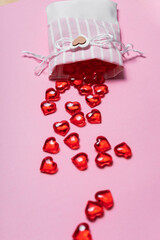selective focus. Valentine's day card. glass red hearts scattered on a pink background. the view from the top. copyspace