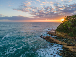 Early morning aerial at the beach with surfers