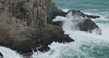 Sea waves splash against rock on island