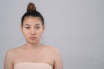 Obraz premium Portrait of asian young beautiful woman without make-up on a white background free from copy space for text. Skincare concept.