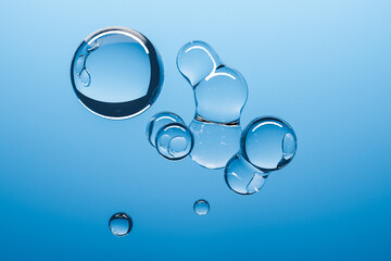 3d illustration of a transparent metaball with a huge number of parts on a blue background. Digital metaball background of flying overflowing into each other shiny spheres.