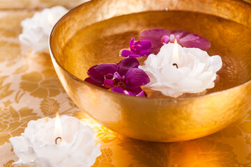 Bowl with water, candles and orchid. Spa, wellness or body care concept.