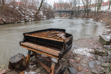 old broken piano outside on a riverbank