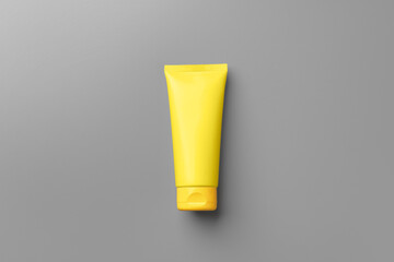 Yellow cosmetic container on gray background top view