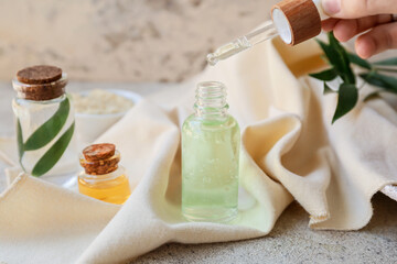 Bottles of natural essential oil on grey background