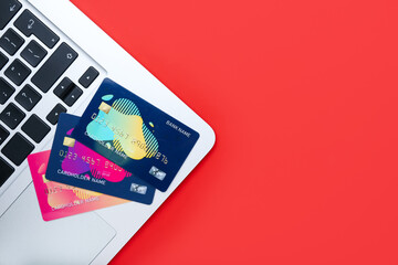 Credit cards and laptop on color background