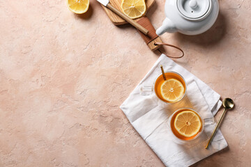 Cups of hot tea with lemon on color background