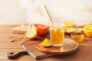 Glass of tasty ice tea on wooden background