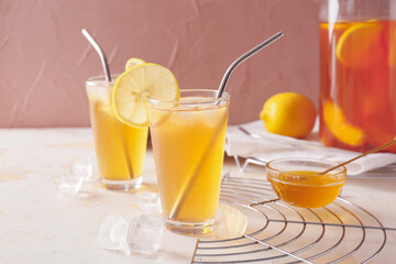 Glasses of tasty ice tea on light background