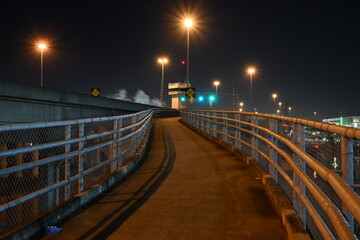 Naklejka premium walkway bridge over river at night