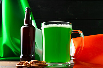 Glass of green beer against flag of Ireland
