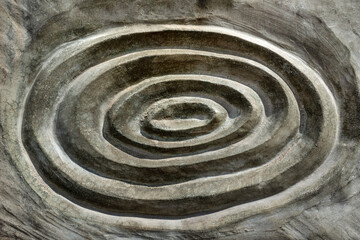Abstraktes rundes Relief Muster aus mehreren Kreisen in grauem Stein in Nahaufnahme