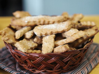 Natural wicker plate with ready made freshly baked cookies. Concept for homemade cookies. Blurred foreground.
