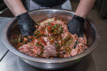 The chef mixes minced pork with different ingredients