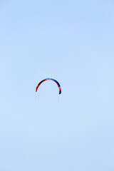 Wing of paraglider on empty blue sky