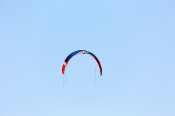 Wing of paraglider on empty blue sky